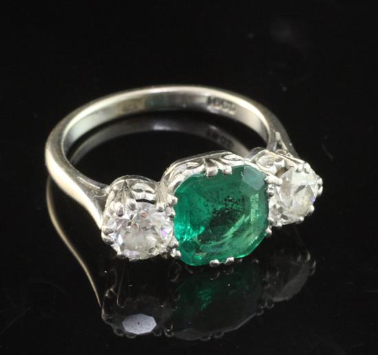 A mid 20th century 18ct white gold, emerald and diamond three stone ring, size K.